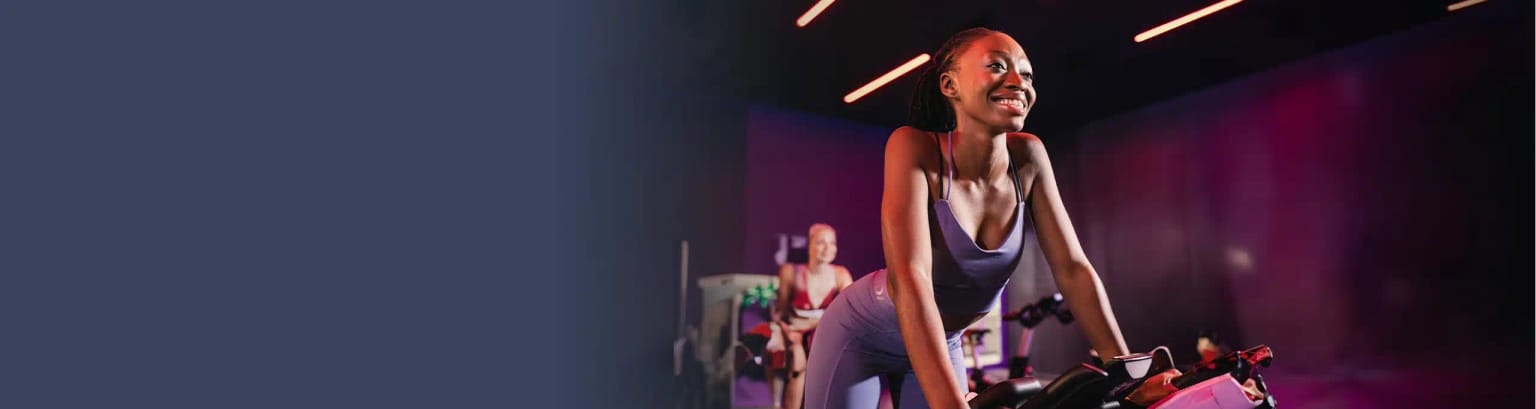 A woman, who has a Virgin Active gym membership, stretches on an exercise mat at a Virgin Active gym.