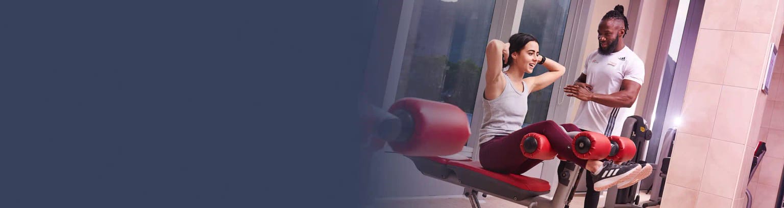 A personal trainer provides a woman with a training session with exercise equipment at a Virgin Active gym.